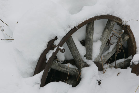 old wagon wheen buried in the snow